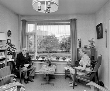 858312 Portret van een ouder echtpaar in hun woonkamer in het Gemeentelijk Bejaardencentrum Tolsteeg (Saffierlaan 10) ...